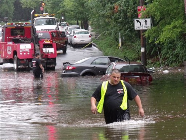 This photo from Sunday, Aug. 14, 2011, shows towing service employees wading through flood waters to reach disabled cars on Amboy Rd., Staten Island, N.Y.  The weather service says showers and thunderstorms are expected to dump about 1-2 inches of rainfall on top of nearly 8 inches of rain that fell on New York City on Sunday.  (AP Photo/Staten Island Advance, Jillian Jorgensen)